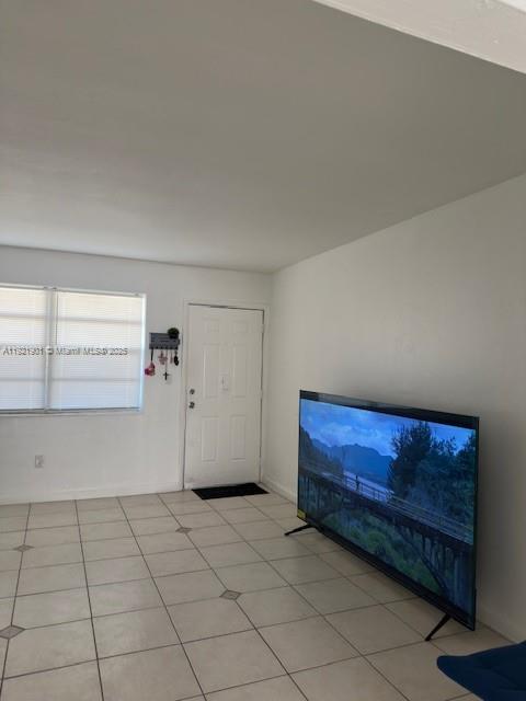 A room with white walls, tiled floors, a window with blinds, and a television — 1350 NE 119th St # 25, Miami FL 33161, MIAMI, FL