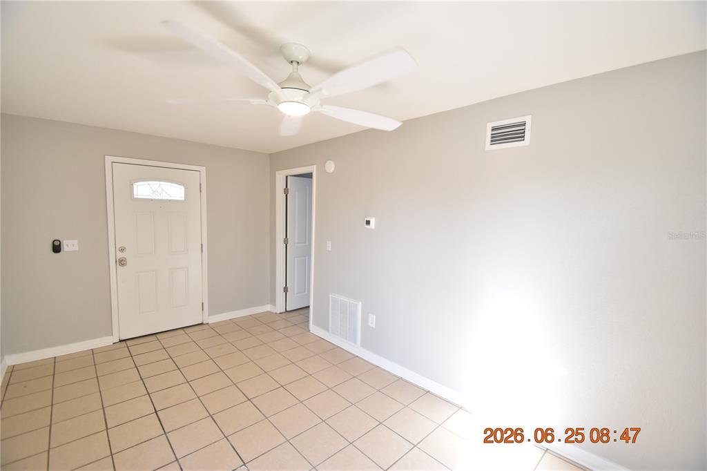 An interior room features light gray walls, a white ceiling fan, and beige tiled flooring — 1254 GROVE STREET UNIT B, CLEARWATER, FL