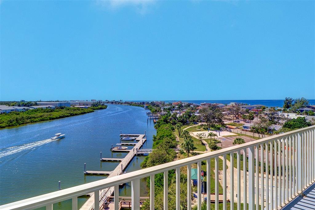 An elevated view from a balcony overlooking a waterway, boat docks, and coastal landscape — 399 2ND STREET UNIT 716, INDIAN ROCKS BEACH, FL