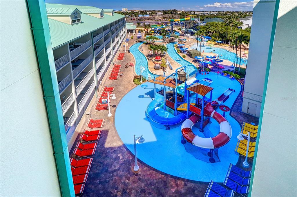 An elevated view of a hotel pool area with a water slide and lazy river — 399 2ND STREET UNIT 716, INDIAN ROCKS BEACH, FL