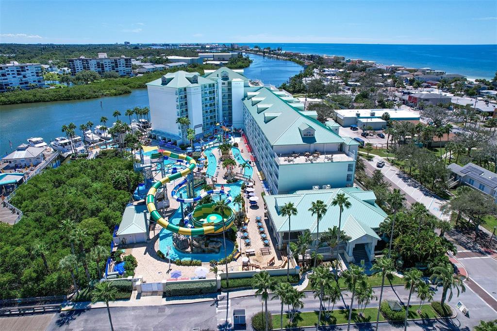 An aerial view shows a large hotel with a water park and swimming pool area — 399 2ND STREET UNIT 716, INDIAN ROCKS BEACH, FL