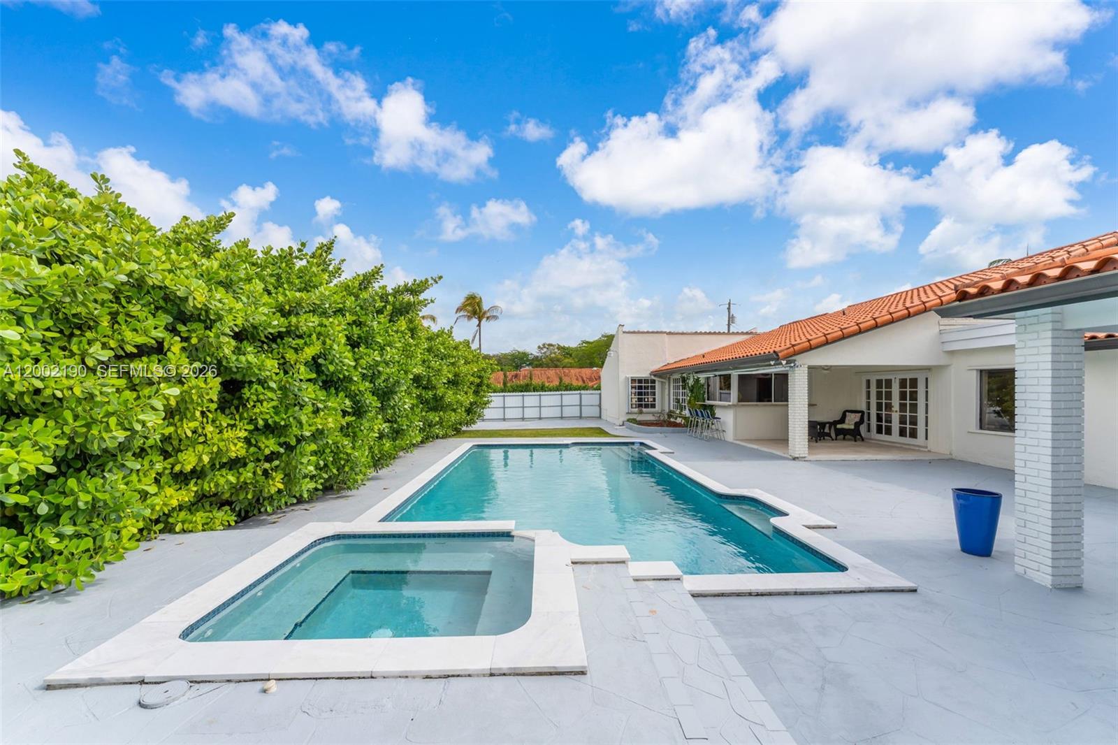 A backyard features a swimming pool, a hot tub, and a patio with a house — 11350 SW 30th St, Miami FL 33165, MIAMI, FL