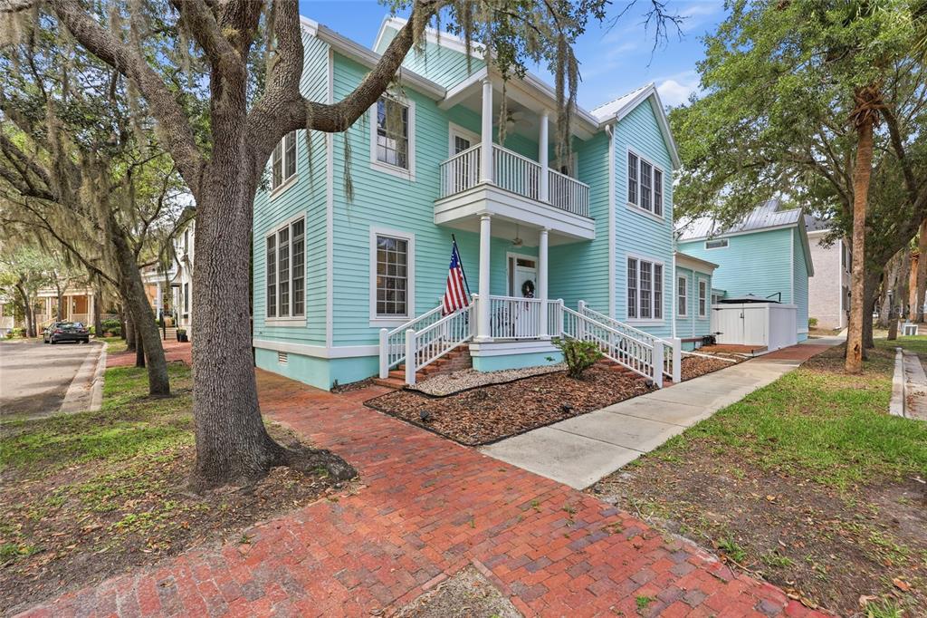 A two-story light blue house with a front porch, white railings, and a brick walkway — 4855 SW 91ST WAY, GAINESVILLE, FL