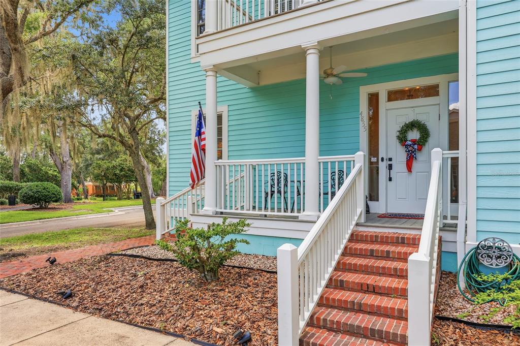 A teal house with a brick staircase leading to a covered front porch and entrance — 4855 SW 91ST WAY, GAINESVILLE, FL