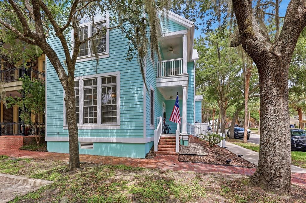 A two-story light blue house with a front porch, white trim, and an American flag — 4855 SW 91ST WAY, GAINESVILLE, FL