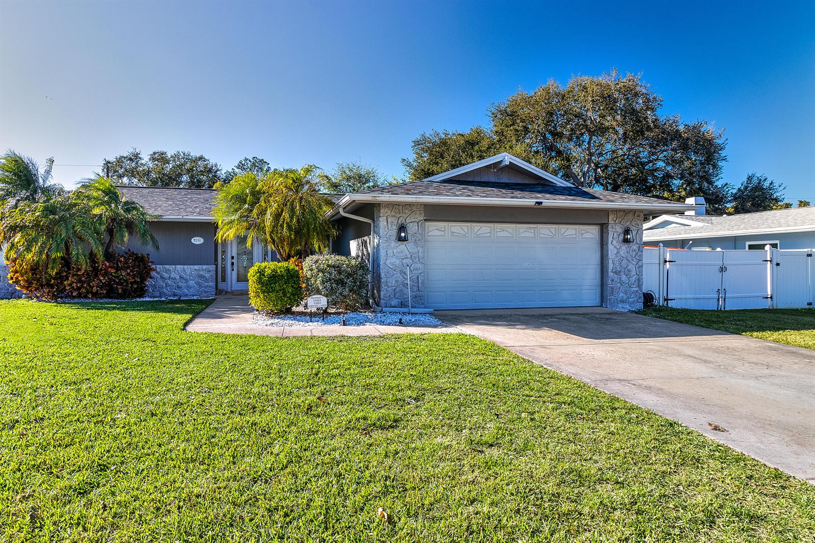 A single-story house with a stone facade, a two-car garage, and a landscaped front yard — 2376 Armour Drive, FL 34698, FL