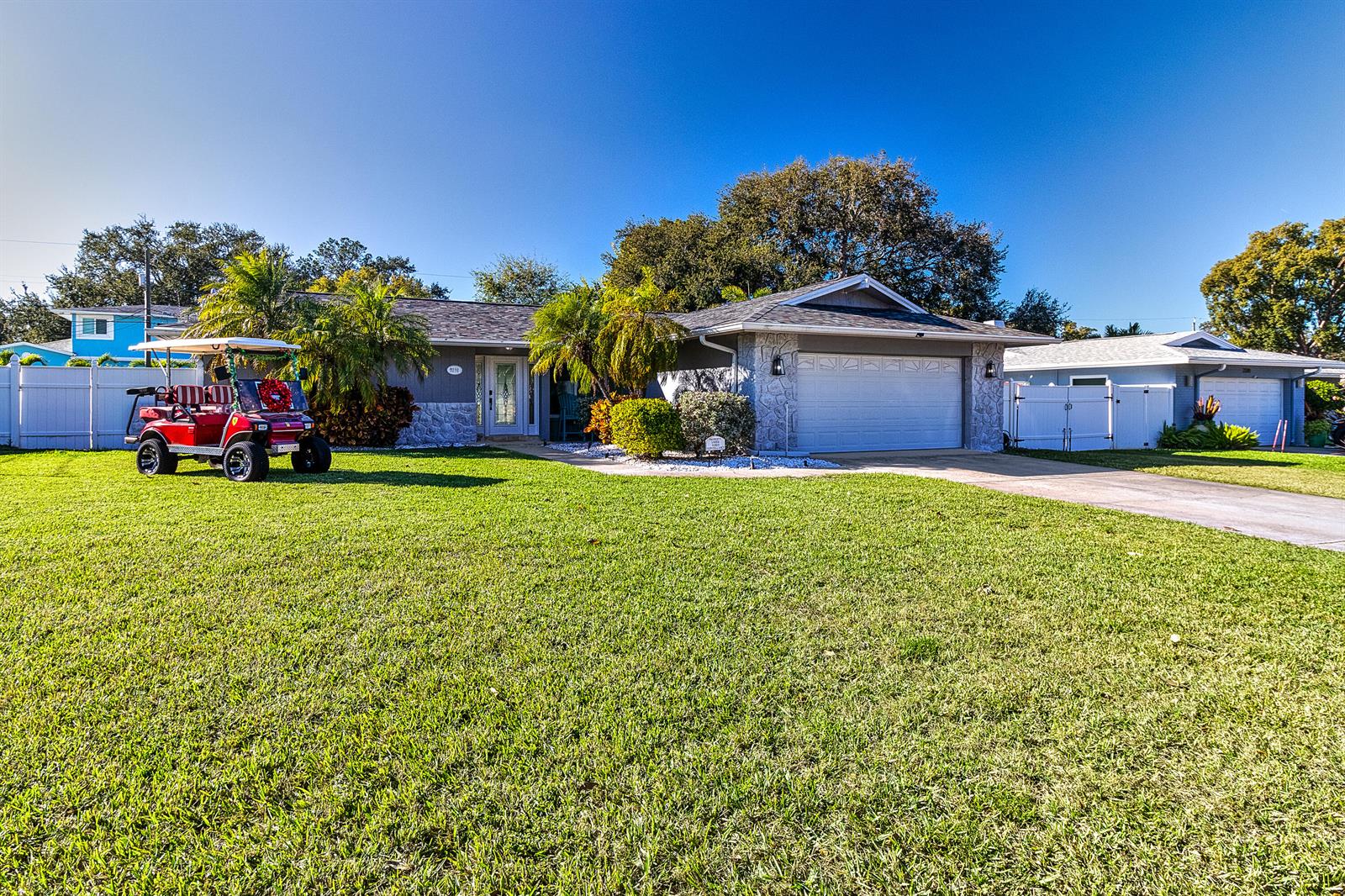 A bright entryway and bar area feature gray tile flooring, white cabinetry, and a surfboard table — 2376 Armour Drive, FL 34698, FL