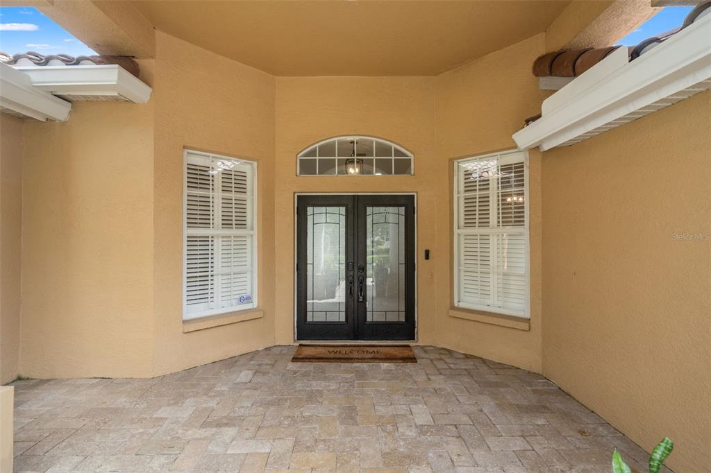 A covered entryway features a double front door with glass panels and two side windows — 18115 REGENTS SQUARE DRIVE, TAMPA, FL