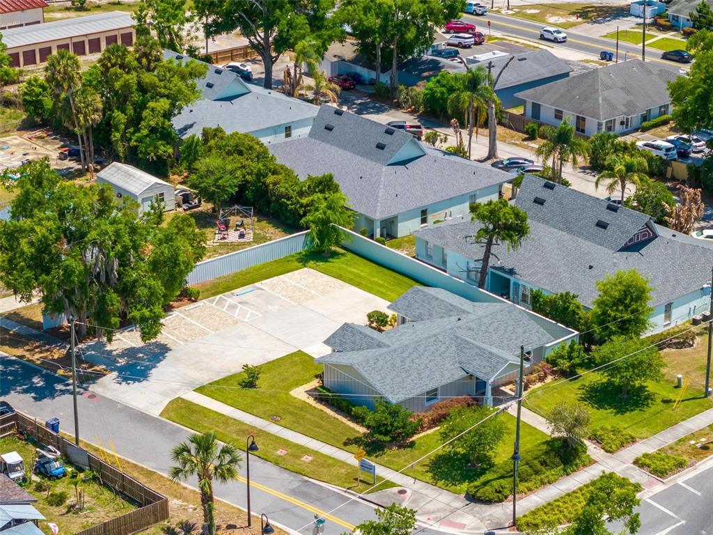 An aerial view shows a single-story house with a large concrete parking area and landscaping — 322 N DISSTON AVENUE, TAVARES, FL