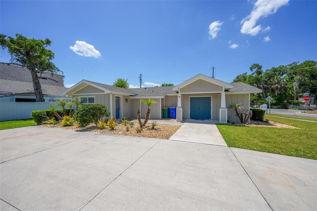 A single-story house with tan siding, a concrete driveway, and a blue double front door — 322 N DISSTON AVENUE, TAVARES, FL