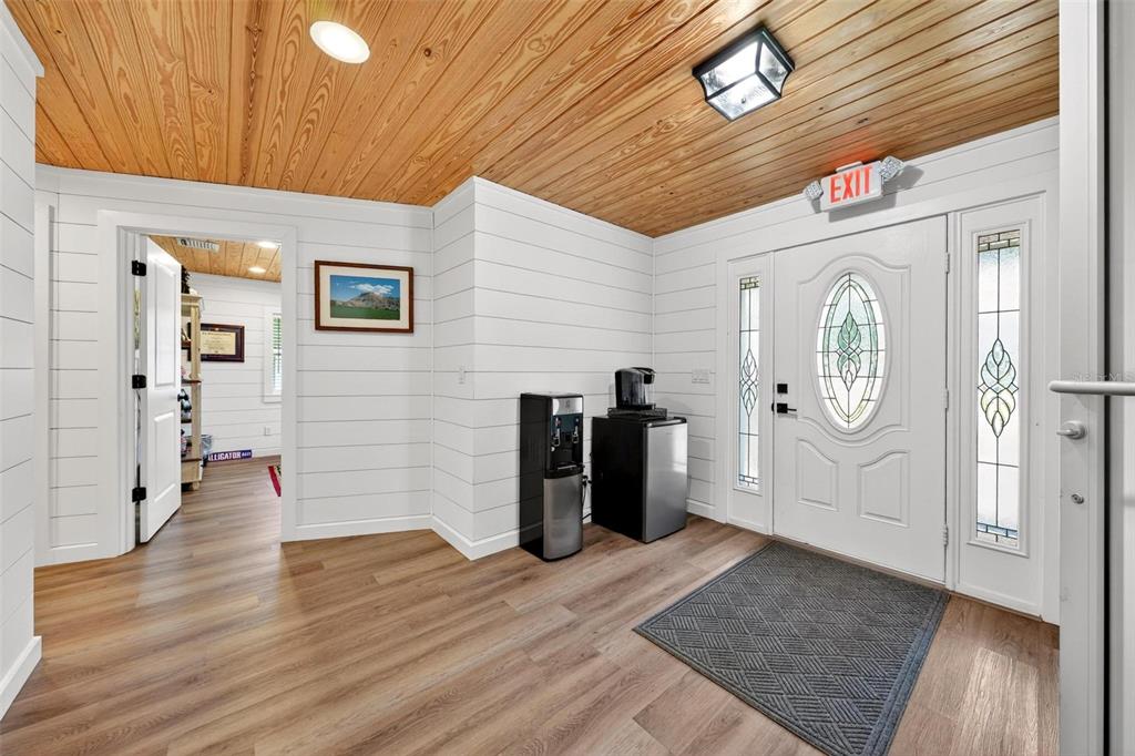An entryway features white shiplap walls, a wood-plank ceiling, and a white front door — 322 N DISSTON AVENUE, TAVARES, FL