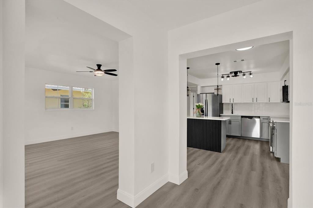 A view from a hallway into a living room and a modern kitchen with island — 4200 HUNTINGTON STREET NE, ST PETERSBURG, FL