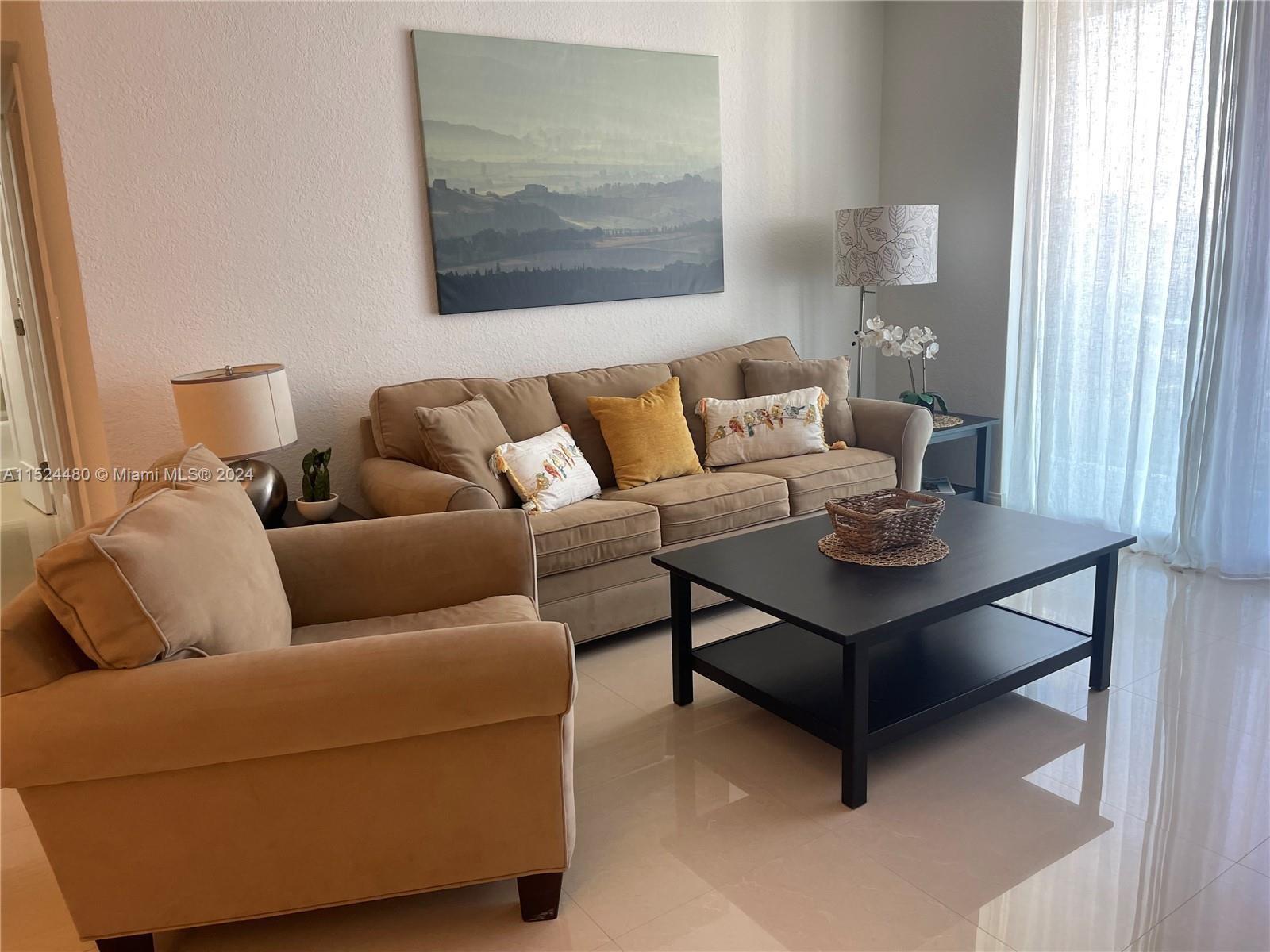 A living room features a beige sofa, an armchair, and a black coffee table — 3801 S OCEAN DR # 15V, Hollywood FL 33019, HOLLYWOOD, FL