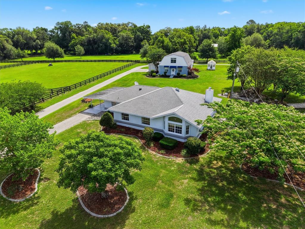 An aerial view shows a single-story house with a detached barn on a grassy lot — 6935 NW HIGHWAY 225A, OCALA, FL