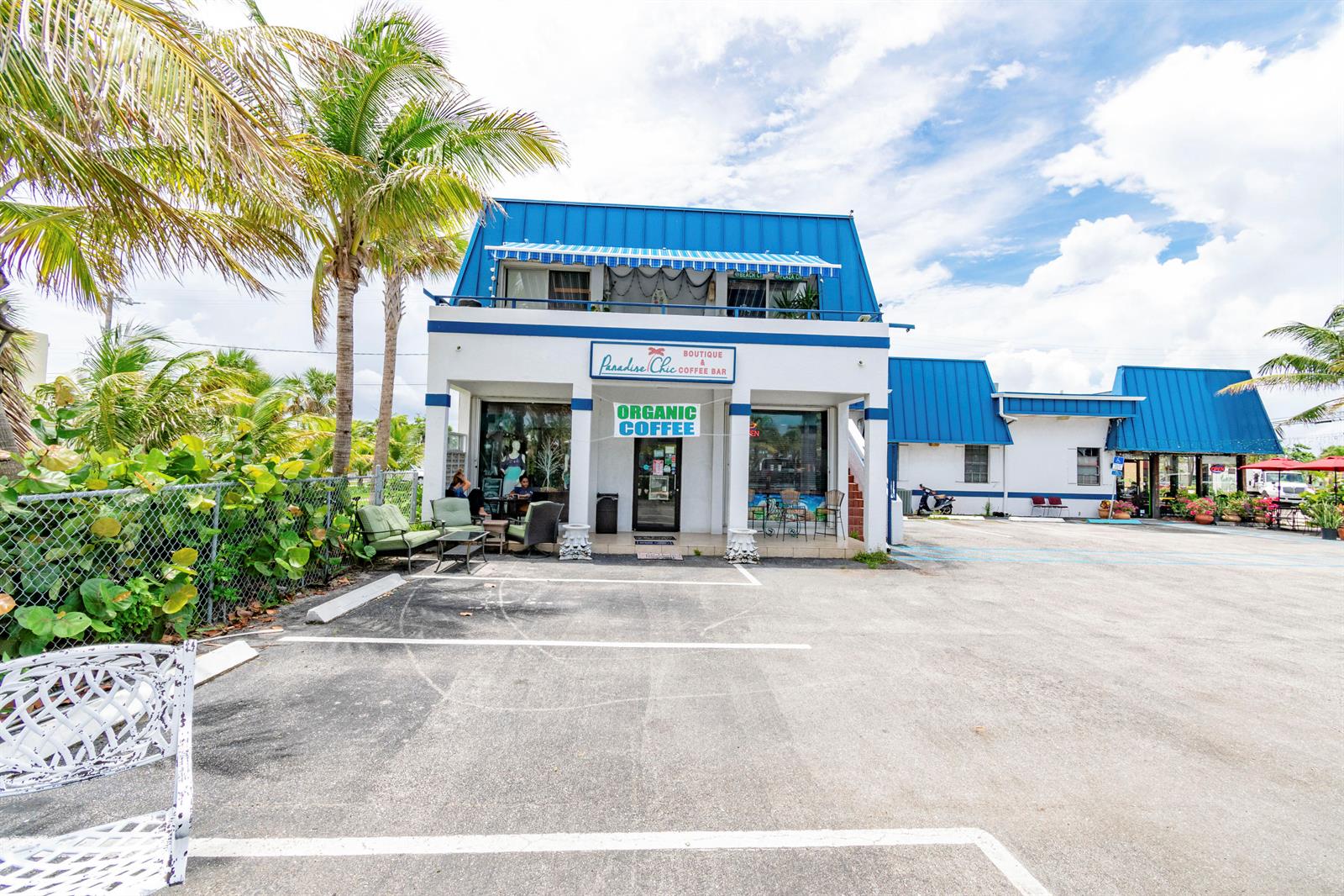 A two-story commercial building with a blue metal roof and an outdoor seating area — 1281 Plaza Circle, FL, FL