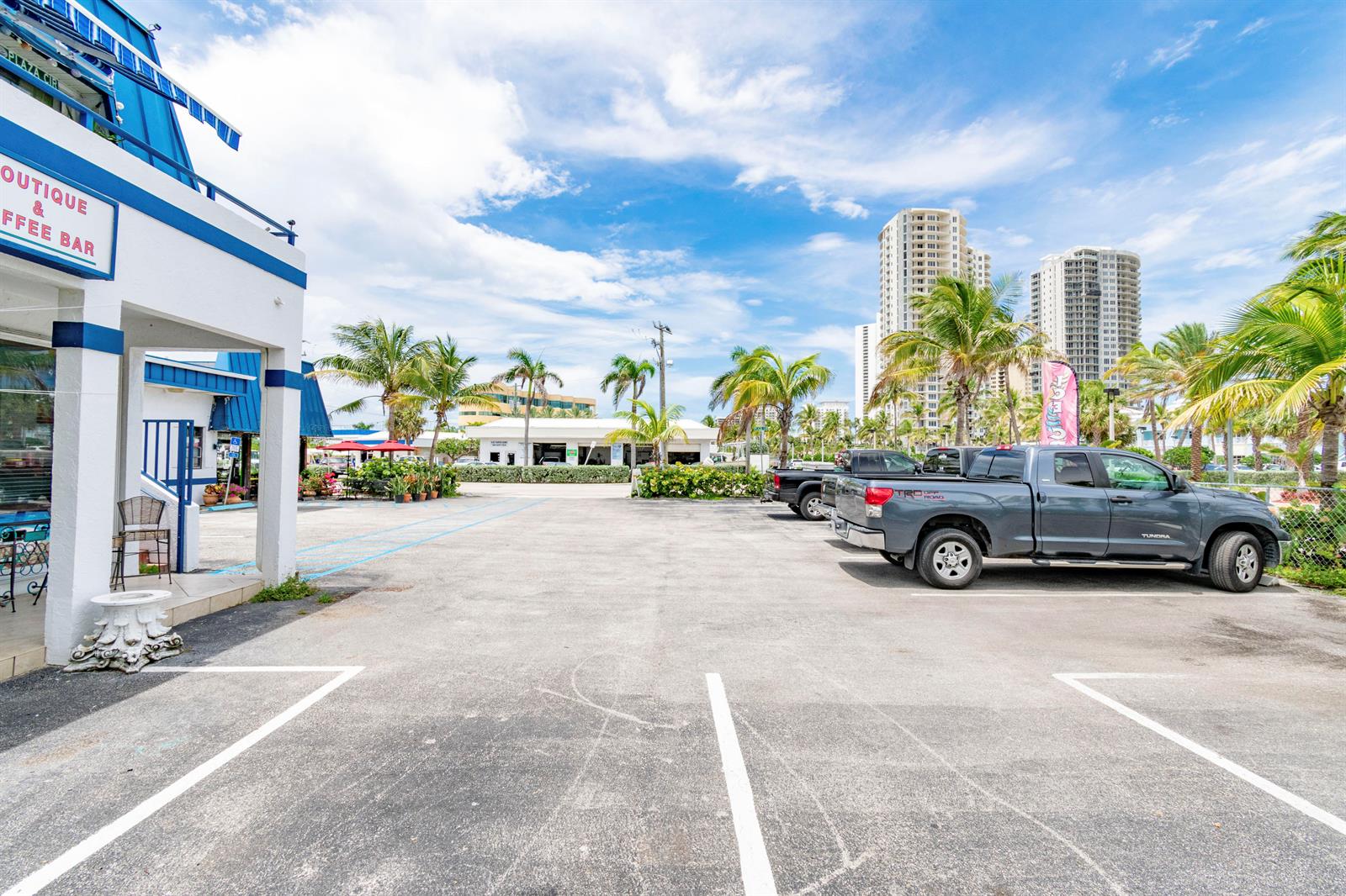 A parking lot with a boutique and coffee bar building and several parked trucks — 1281 Plaza Circle, FL, FL