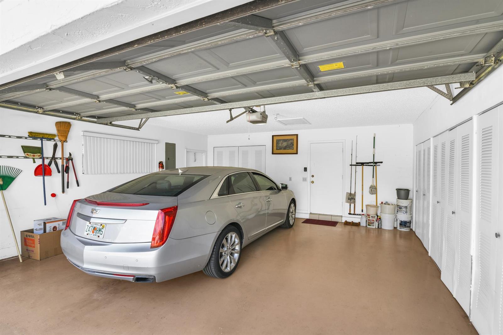 A silver sedan is parked inside a garage with white walls and a tan floor — 2660 Riviera Drive, Delray Beach FL 33445, DELRAY BEACH, FL