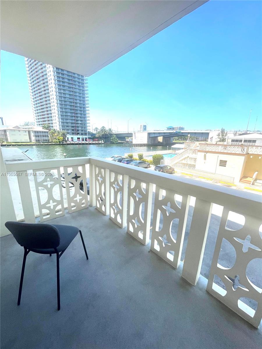 A balcony with a decorative white railing overlooks a waterway, a bridge, and tall buildings — 1817 S Ocean Dr # 219, Hallandale Beach FL 33009, HALLANDALE BEACH, FL