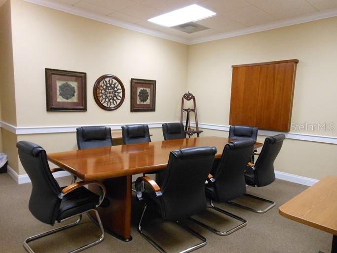 A conference room features a long wooden table surrounded by eight black office chairs — 1740 SE 18TH STREET UNIT 901, OCALA, FL