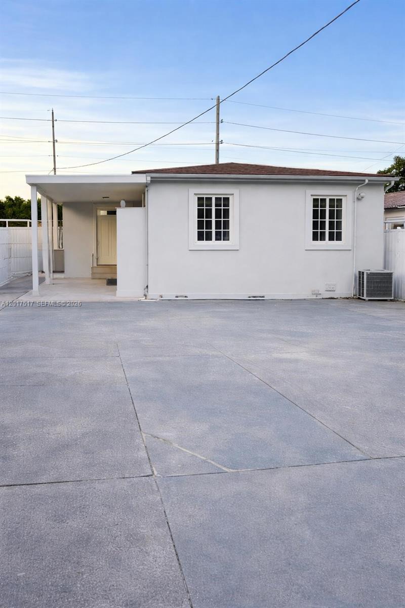 A single-story white house features a covered entryway and a large concrete driveway — 538 E 13th St, Hialeah FL 33010, HIALEAH, FL