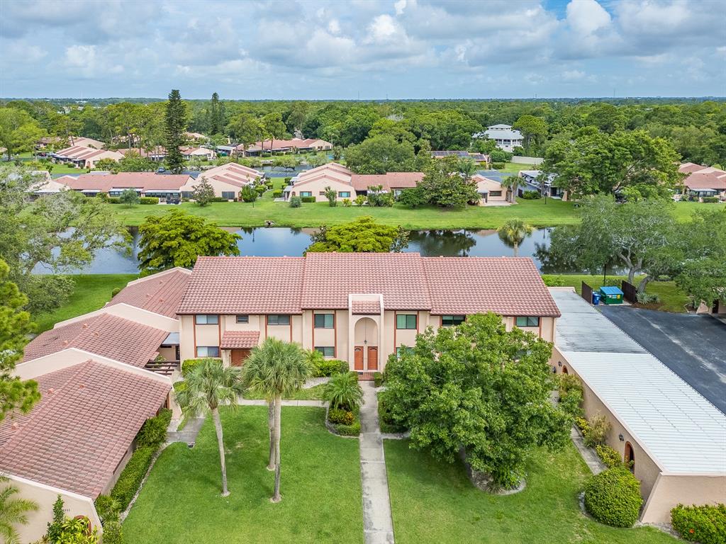 An aerial view of a multi-unit residential building with a tiled roof and green lawn — 9543 86TH AVENUE UNIT 9543, SEMINOLE, FL