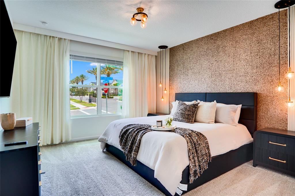 A bedroom features a textured accent wall, a black bed frame, and a large window — 2341 SALTY WINDS WAY, KISSIMMEE, FL