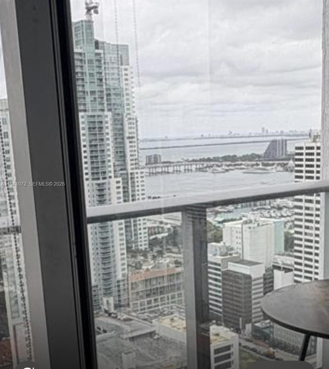 A high-rise balcony view overlooks a city skyline, a bridge, and a body of water — 151 SE 1st St # 3404, Miami FL 33131, MIAMI, FL
