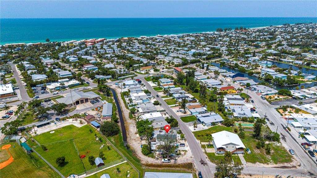 An aerial view shows a residential neighborhood near the coast with a marked property — 455 62ND STREET, HOLMES BEACH, FL