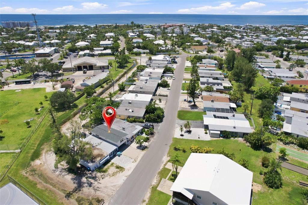 An aerial view shows a residential neighborhood with a red location pin over a house — 455 62ND STREET, HOLMES BEACH, FL
