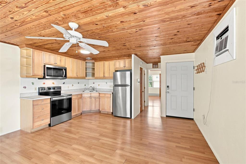 A kitchen features light wood cabinets, stainless steel appliances, and a wood-paneled ceiling — 455 62ND STREET, HOLMES BEACH, FL