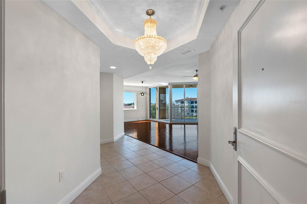 A tiled entryway leads to a living area with hardwood floors and a crystal chandelier — 5823 BOWEN DANIEL DRIVE UNIT 401, TAMPA, FL