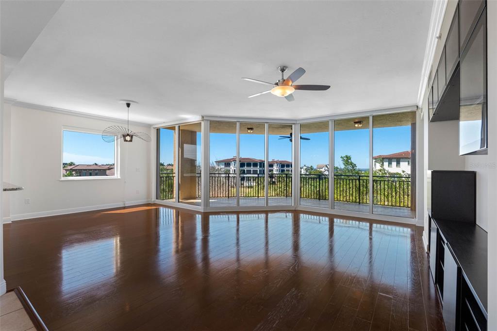 A living room with dark hardwood floors, a ceiling fan, and large floor-to-ceiling glass doors — 5823 BOWEN DANIEL DRIVE UNIT 401, TAMPA, FL