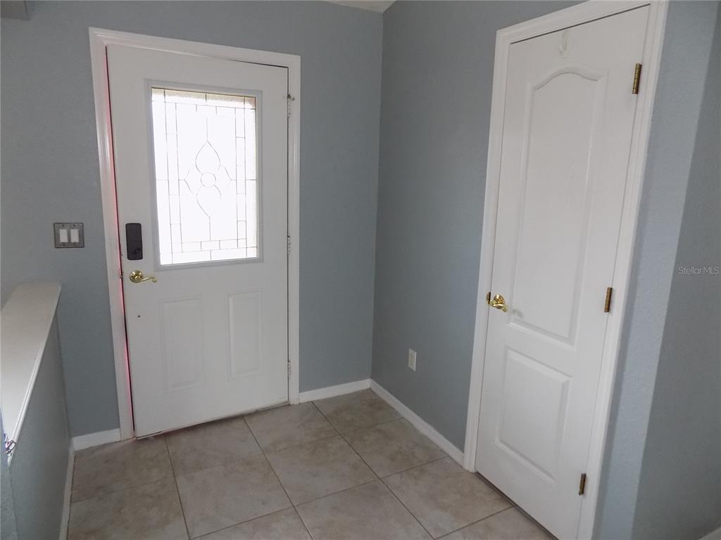 An entryway features a white front door, a white closet door, and tiled flooring — 2047 W PARAGON LANE, CITRUS SPRINGS, FL