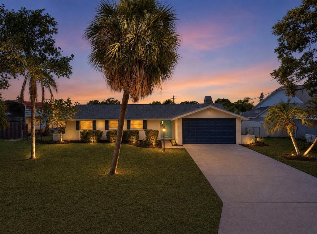 A single-story house with a dark blue garage door and a palm tree-lined front yard — 617 GOLF AND SEA BOULEVARD, APOLLO BEACH, FL