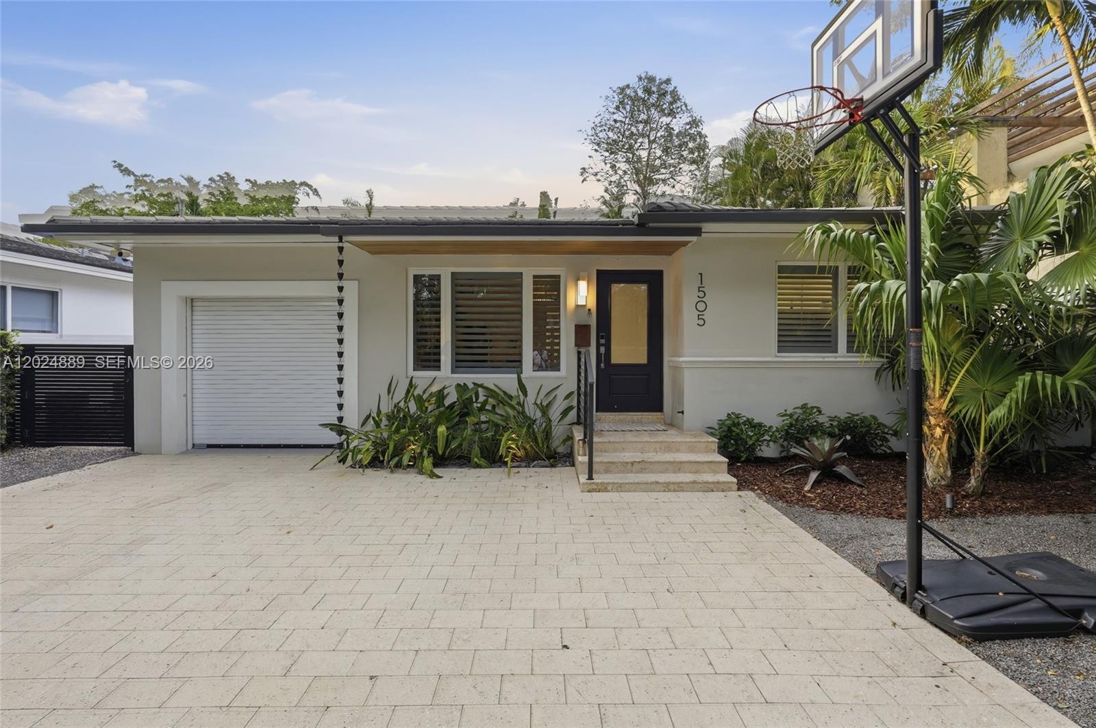 A single-story house exterior features a paved driveway, a garage, and a basketball hoop — 1505 Robbia Ave, Coral Gables FL 33146, CORAL GABLES, FL