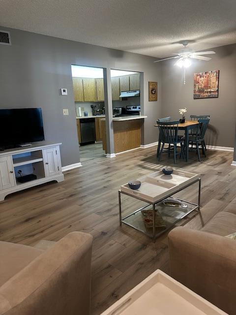 A living room and dining area feature light wood flooring, gray walls, and a ceiling fan — 441 Pine Glen Lane # 2, FL 33463, FL