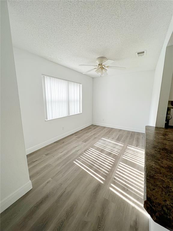 A dining area features light wood-look flooring, white walls, and a ceiling fan — 2425 BARLEY CLUB DRIVE UNIT 8, ORLANDO, FL