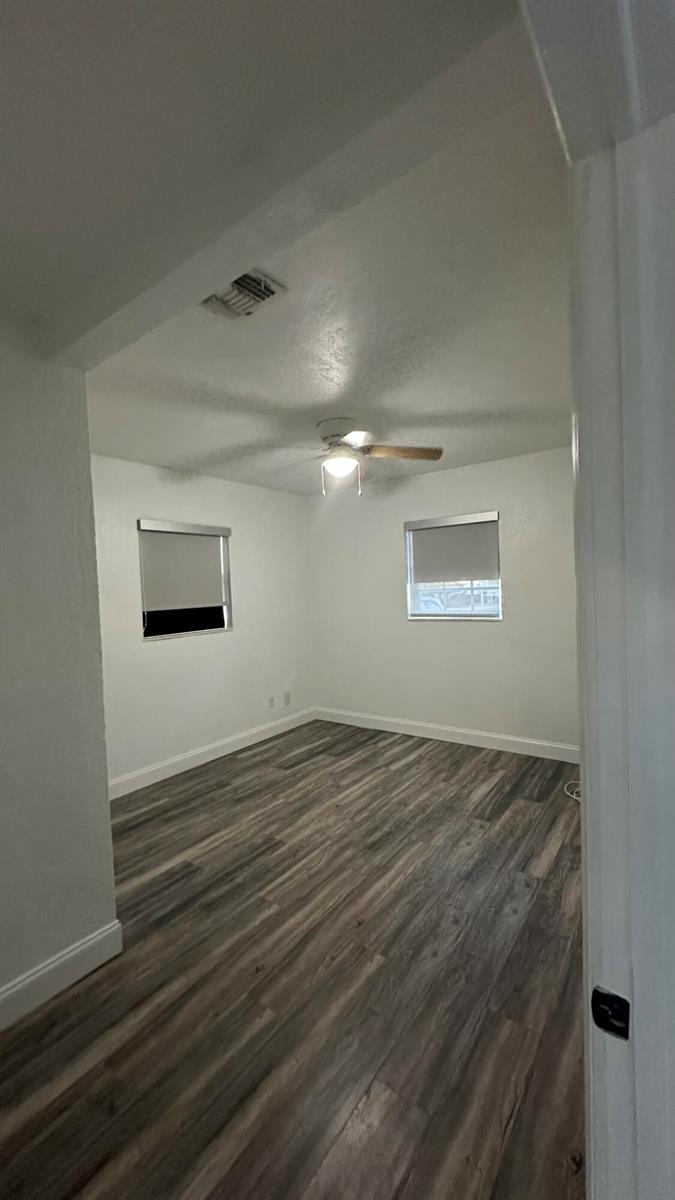 An empty bedroom features white walls, a ceiling fan, and wood-look laminate flooring — 4628 SW 32nd Drive, West Park FL 33023, WEST PARK, FL