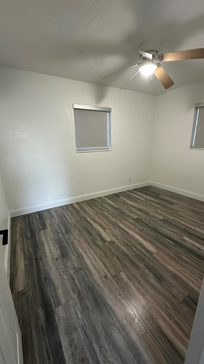 An empty bedroom features white walls, a ceiling fan, and wood-look laminate flooring — 4628 SW 32nd Drive, West Park FL 33023, WEST PARK, FL