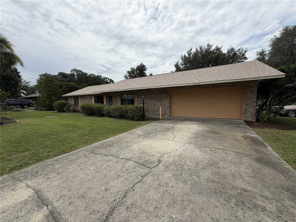 A single-story brick house with a two-car garage and a cracked concrete driveway — 2776 NE 31ST PLACE, OCALA, FL