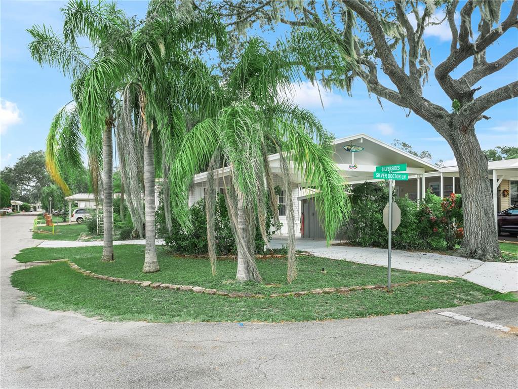 A single-story home with a carport and palm trees sits on a corner lot — 37 SILVER DOCTOR LANE, LAKE WALES, FL