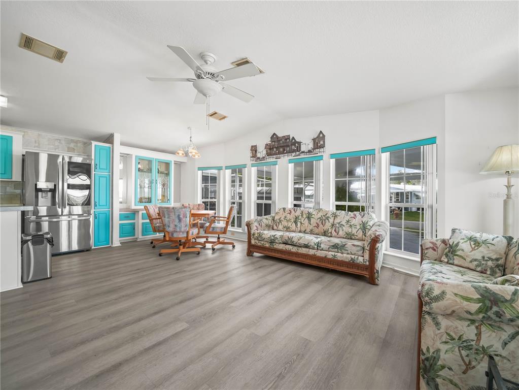 A living and dining area features wood-look flooring, a ceiling fan, and turquoise kitchen cabinets — 37 SILVER DOCTOR LANE, LAKE WALES, FL