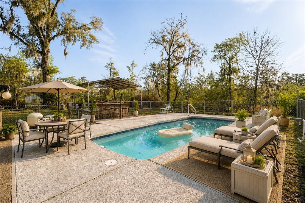 An elevated house with a wrap-around wooden deck and concrete block support pillars — 7281 SW 68TH DRIVE, JASPER, FL
