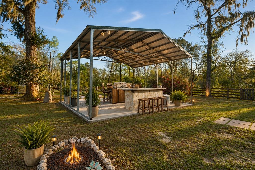 A stilt house sits at the end of a sandy driveway behind a wooden fence — 7281 SW 68TH DRIVE, JASPER, FL
