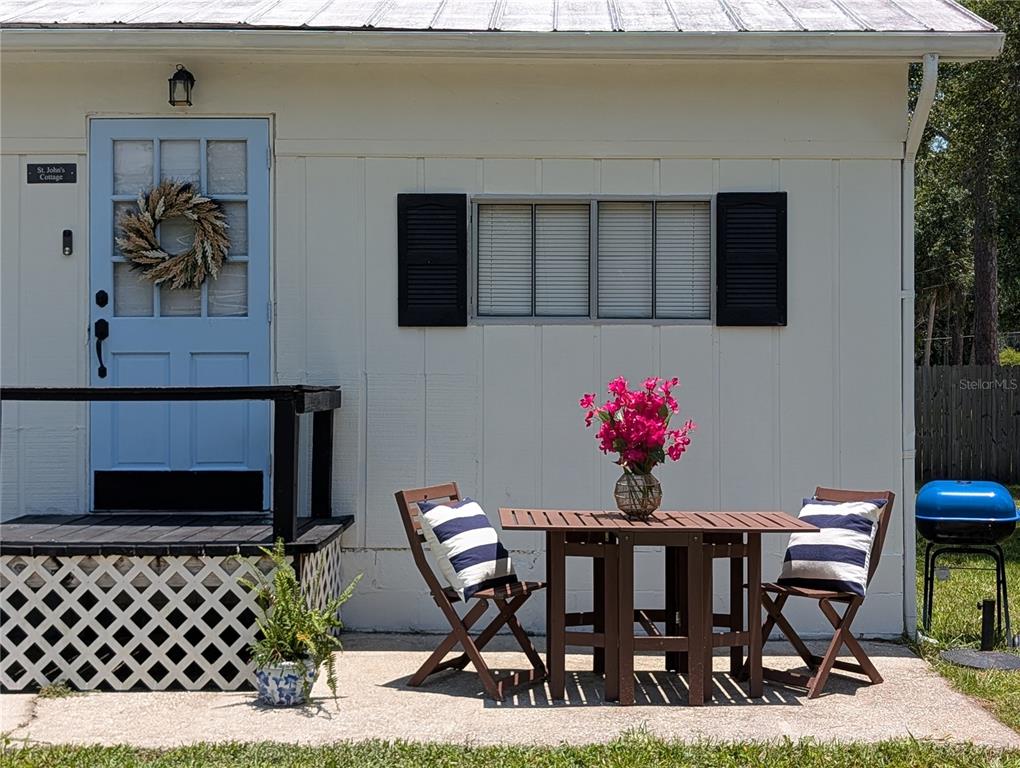 A light blue door and a small patio with a table and chairs outside — 55914 BAY ROAD, ASTOR, FL