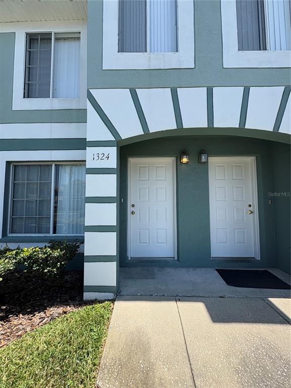 The exterior of a two-story building features two white front doors under an arched entryway — 1324 KELRIDGE PLACE, BRANDON, FL
