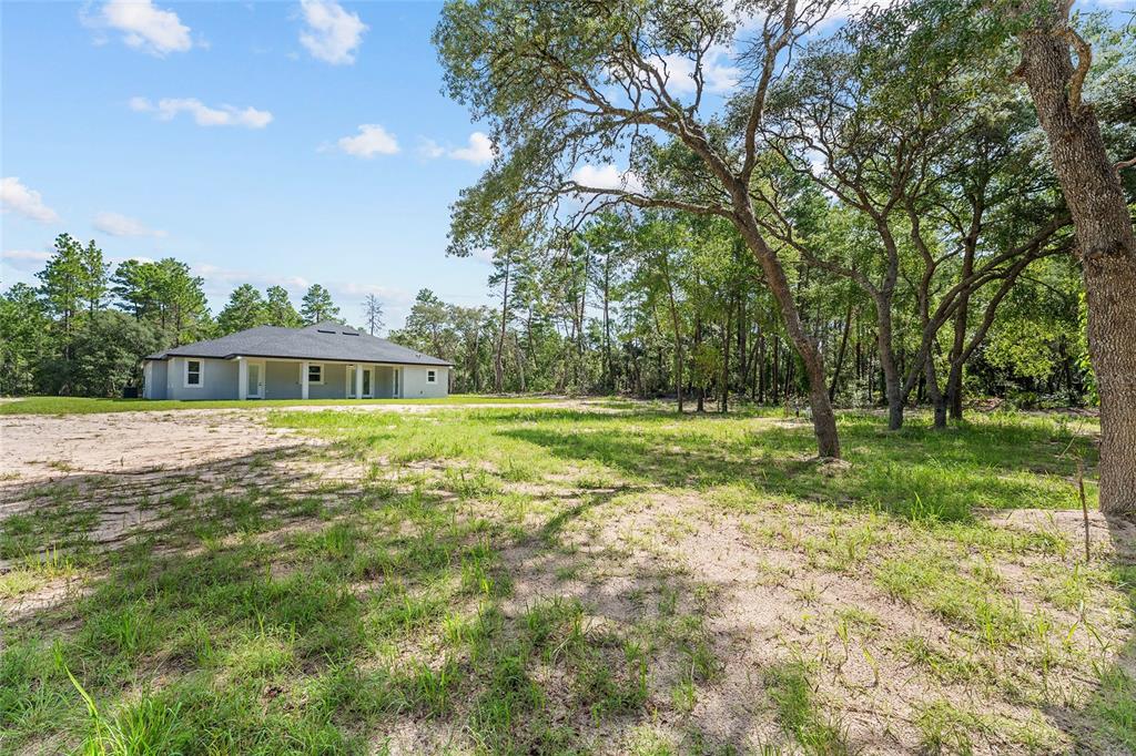 An aerial view shows a single-story house with a dark roof surrounded by sandy land — 4660 SW 179TH PLACE, OCALA, FL