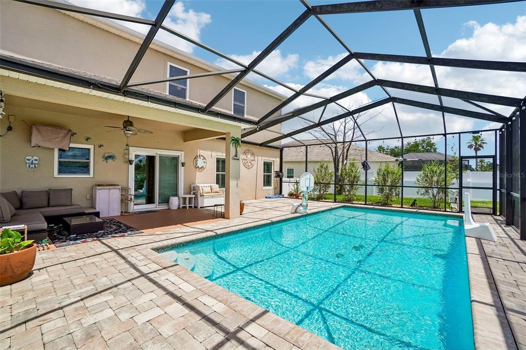 A screened-in patio features a swimming pool, outdoor seating, and a paved deck — 15792 DURANGO CIRCLE, BROOKSVILLE, FL