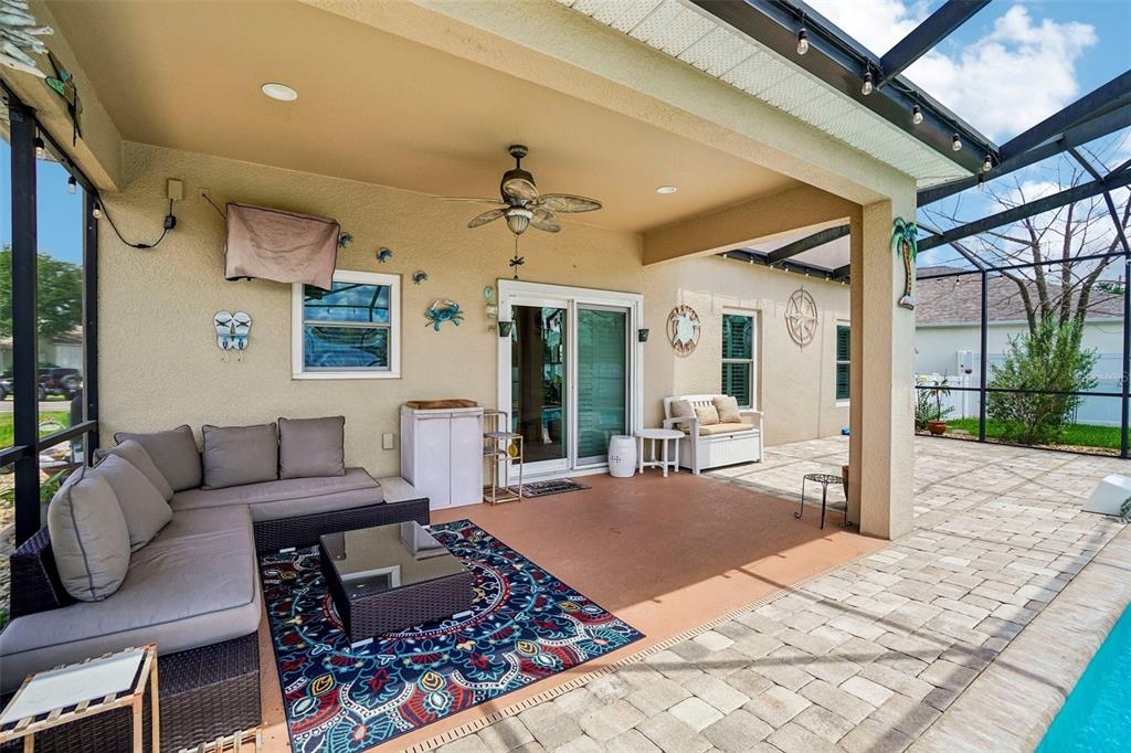 A covered patio features a sectional sofa, a patterned rug, and a pool enclosure — 15792 DURANGO CIRCLE, BROOKSVILLE, FL