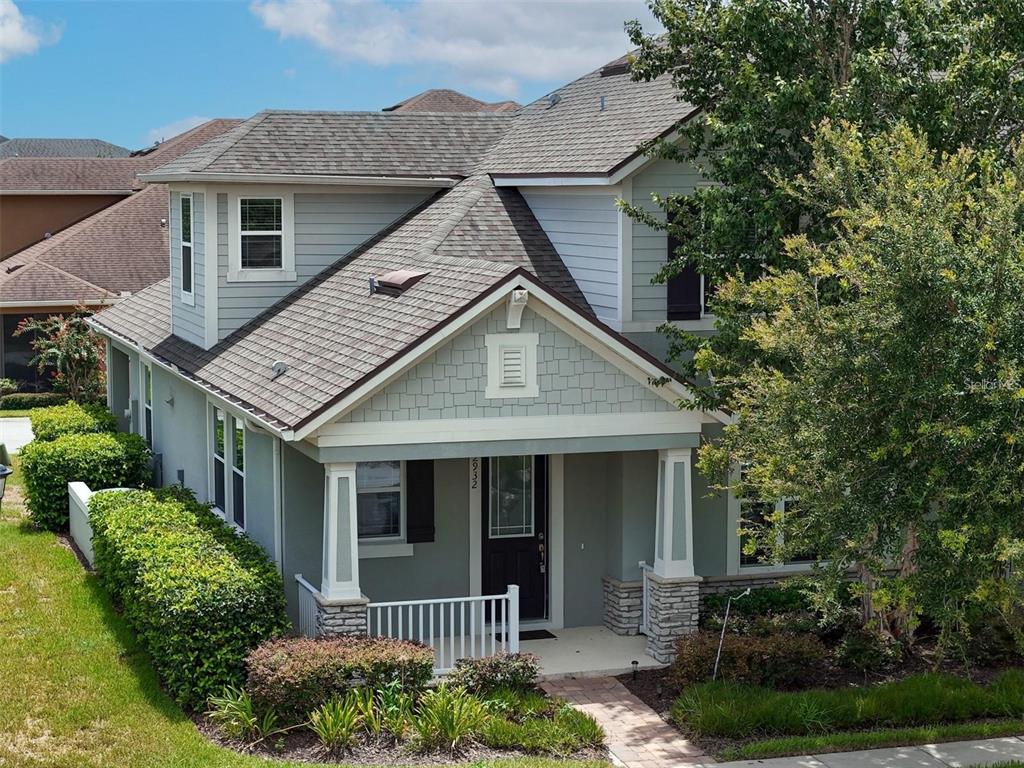 An exterior view of a two-story house with a front porch, siding, and shingled roof — 2932 CELLO LANE, KISSIMMEE, FL